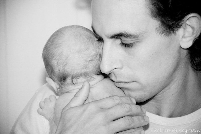 Dad cuddling a newborn baby - newborn portrait photography sydney